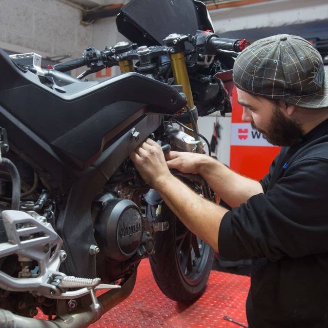 Mekaniker jobber ved hjulet på motorsykkel